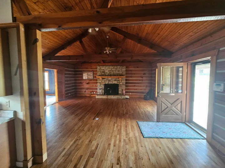 The Lodge — great room with stone fireplace and vaulted log ceiling